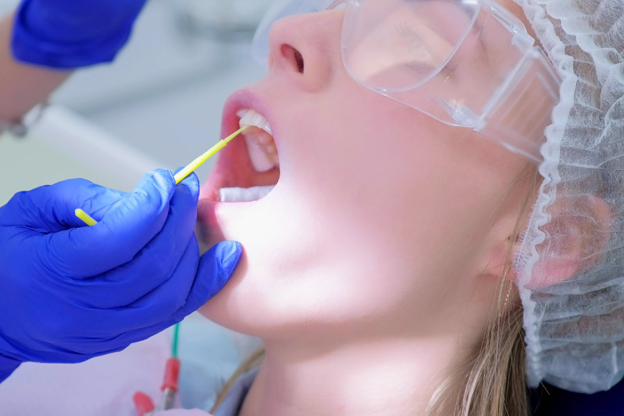 Patient in the dental chair receiving a fluoride treatment.