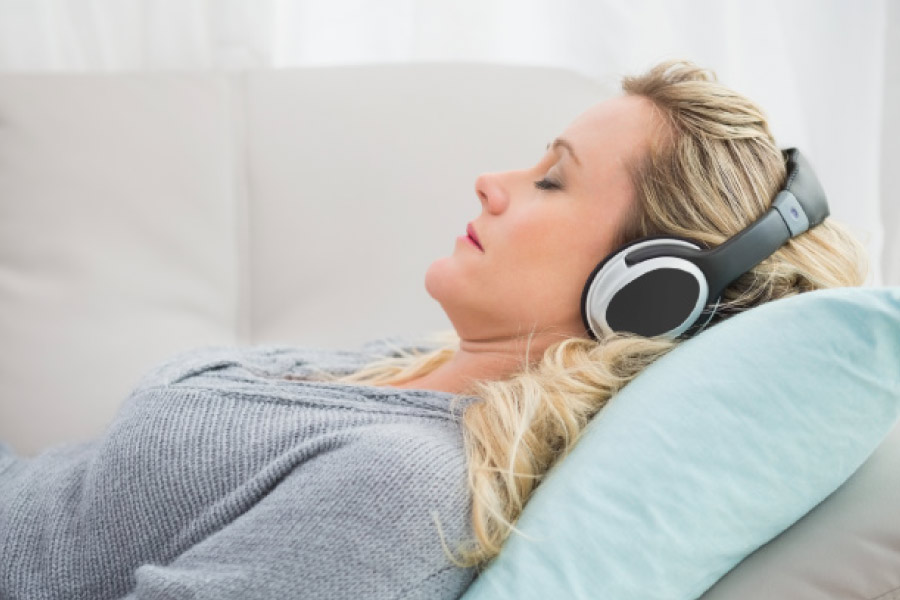 Woman relaxing at the dentist with headphones to help with dental anxiety.