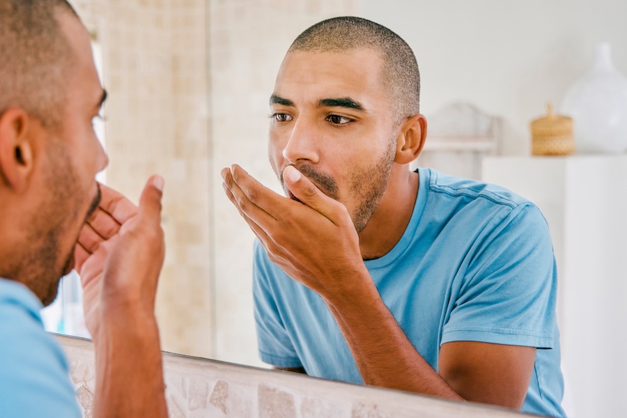 man with bad breath or halitosis, causes of halitosis