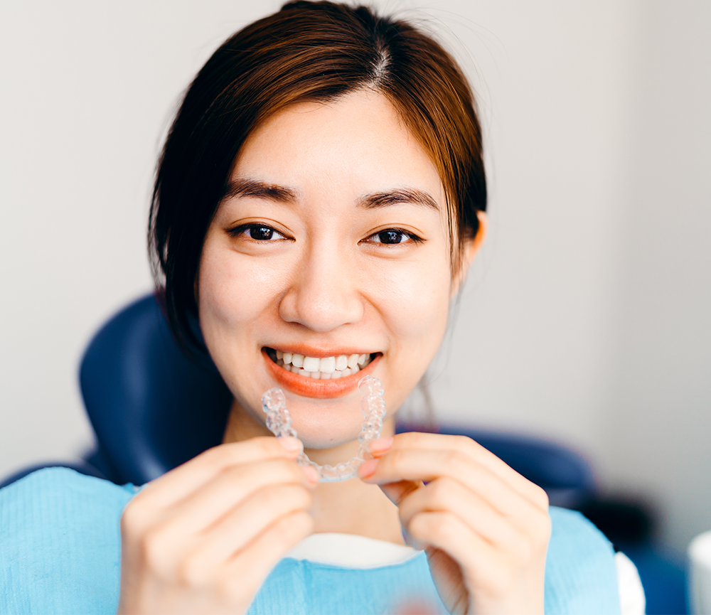 woman holding clear aligner