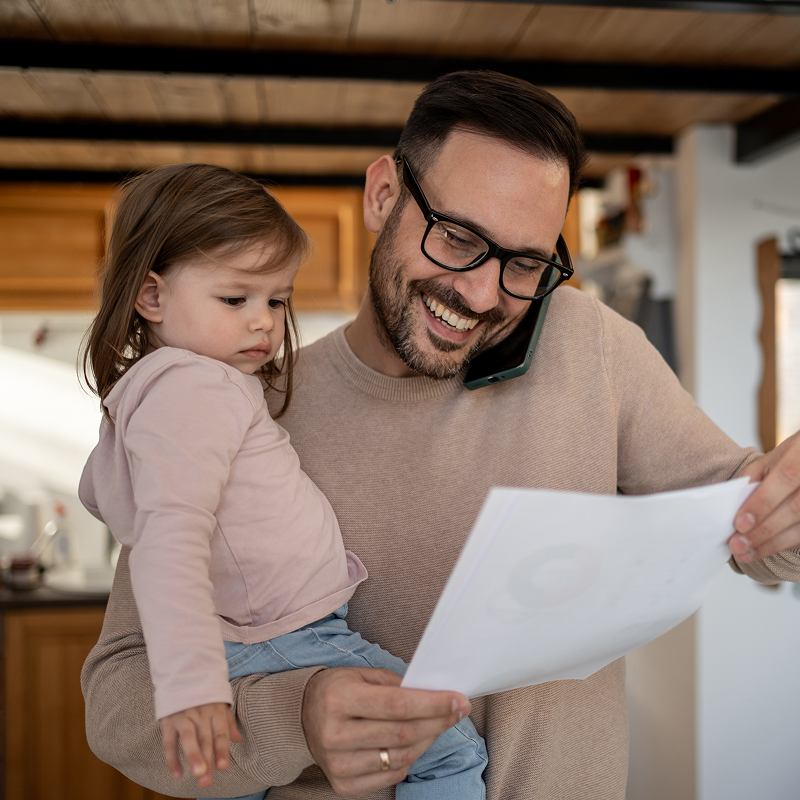 Dad on the phone holding daughter