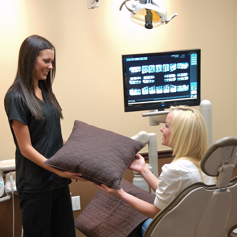 dental associate giving a pillow to patient