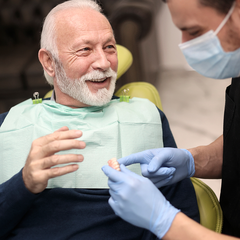 senior man being shown dentures